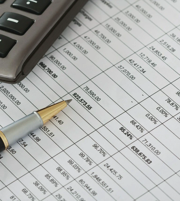 Dokumenty finansowe z&nbsp;wykresami i&nbsp;kalkulatorem na&nbsp;biurku